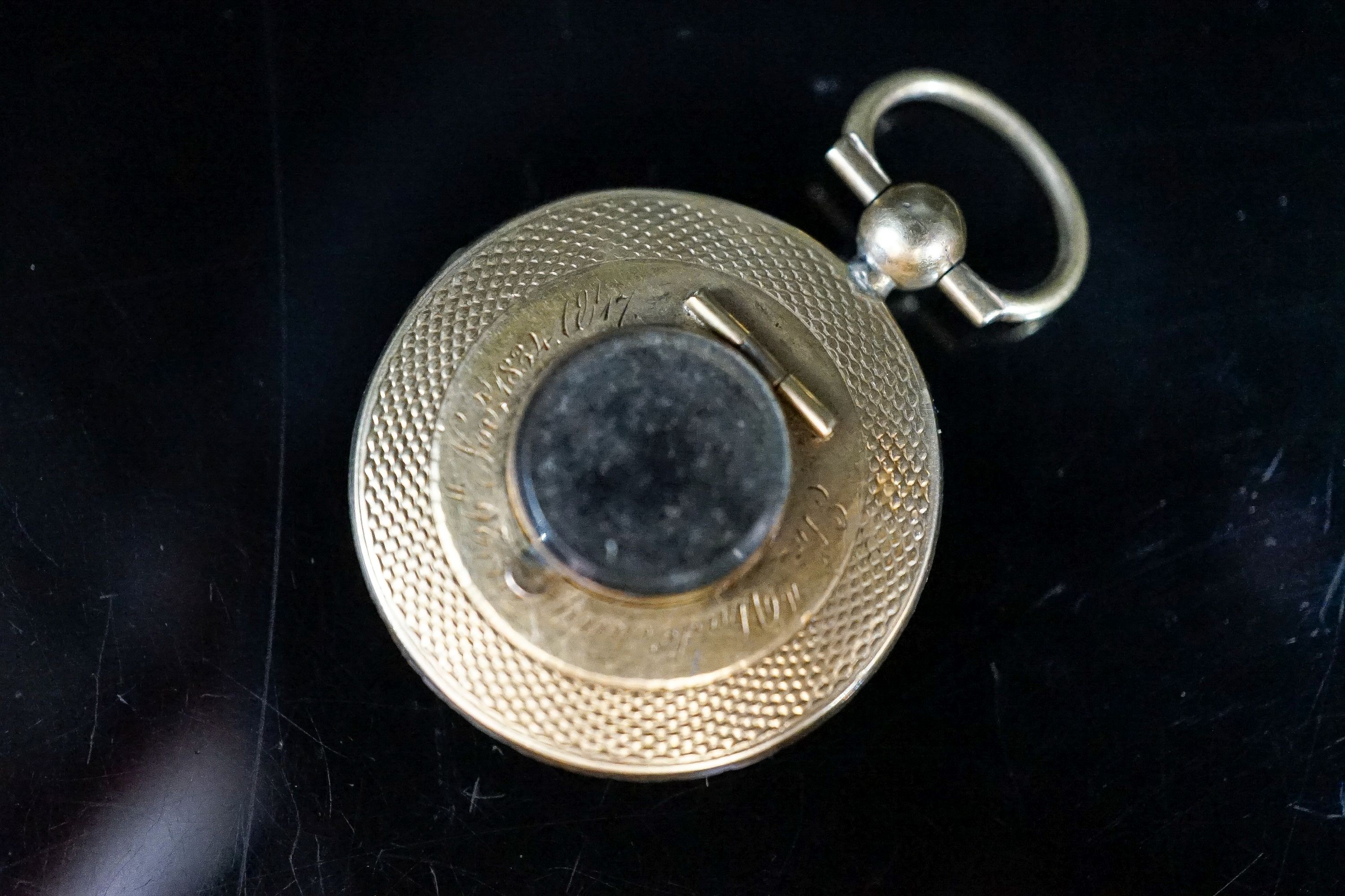 A William IV yellow metal, black enamel and split pearl mounted glazed circular mourning pendant vacant enamelled mourning brooch, 25mm. with engraved inscription, gross 6.5 grams.
